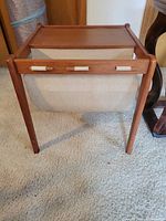 Top front view of teak-tone magazine rack with fabric sling