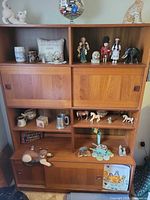 Front view of entire teak wall unit with shelves and sliding doors