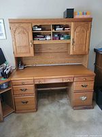 Front view showing entire oak desk with hutch, drawers and shelving