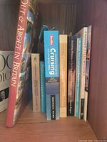 Group view of books on shelf showing titles Out & About in Britain, Berlitz Cruising guide and others