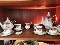 Shelf view showing both pots, four cups on saucers and creamer