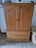 Front view of armoire with doors closed and exterior drawers visible