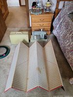 Overall view of sewing machine, case, foldable grid board and accessories