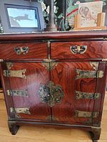 Front view of cabinet closed showing drawers and brass hardware