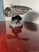 Front view of entire silver-plated cherub dish under leaf