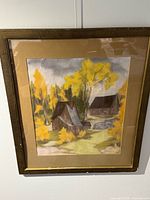 Front view of framed painting showing autumn cabin scene