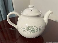 Full left-side view of teapot showing handle, spout, pattern, lid