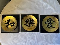 Front view of all three plaques showing designs