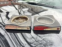 Front view of both square concrete ashtrays showing labels and bowl condition