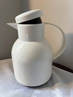 Side view of white insulated carafe with lid and handle