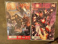 Front covers of both Iron Man comics bagged & boarded