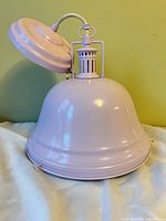 Side view of pastel pink metal pendant light showing dome shade and upper fitting