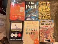 Front covers of all six books displayed on tabletop