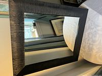 Front view of mirror showing black textured frame and glass