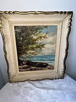 Front view of framed coastal oil painting showing artwork and ornate frame