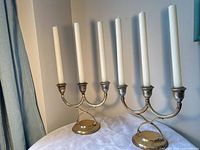 pair of brass 3-arm candelabras with candles front view
