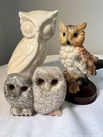 Front view of all three owl figurines showing materials and relative sizes