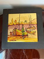 Frontal view of framed enamel tile showing complete harbor scene artwork