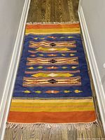 Full view of rug laid flat showing complete pattern and fringe