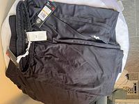 Folded black Under Armour athletic shorts with hang tag visible