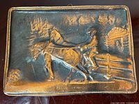 Front view of rectangular cast metal plaque showing raised rural horse scene