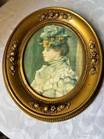 Front view showing portrait print and ornate gold oval frame