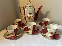 Full tea set showing teapot, five cups and saucers