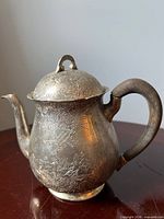 Full view of teapot showing overall form and engravings