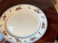 Top view showing floral design, blue rim, and crack on surface