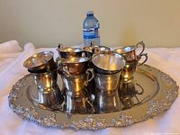 Tray with cups stacked inside alongside water bottle for scale