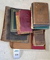 Stack of assorted antique books showing worn covers and spines