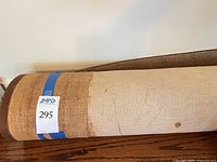 Rug rolled showing backing with stains and lot sticker