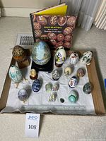 Overview of all eggs on tray with book and ruler for scale