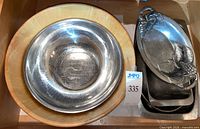 Wood salad bowl with stainless steel bowl nested, and stack of metal platters