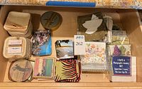 Drawer view showing stacks of coasters, cloth napkins, packaged paper napkins and napkin holders