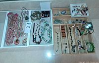 Overview of lot showing necklaces, cameo brooches, bracelets, earrings