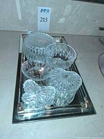 All five crystal and glass items grouped on mirrored tray