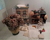 Group shot of all items including planter with hydrangea, jewelry chest, baker’s rack, linens, compact, Kat Burki box