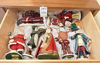 Eight Santa figurines in drawer with tissue wrap