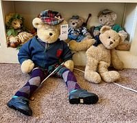 Group of four teddy bears showing clothing and sizes