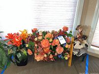 Group shot of floral arrangements, chair with plush toys, ruler for scale