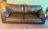 Front view of brown faux leather couch showing seat and back cushions