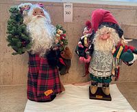 Two Santa figurines side by side