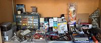 Shelf view showing organizer cabinet, spray cans, label maker, tools and packaged items