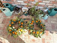 overview of wreaths, watering cans, and planters on patio