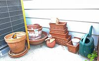 Group of terracotta planters, rectangular planters, small ceramic pot, watering can and sprinkler