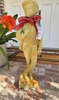 Full view of 34" painted concrete young man statue with removable red ribbon
