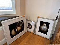 All three framed prints leaning against wall