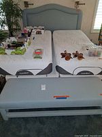 Full view of headboard behind twin mattresses and matching bench in front