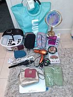Group shot showing laundry tote, foot spa, scale, bags, mirror, hair tools, pouches and crystal
